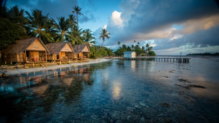 Bungalows on a tropical beach at sunrise