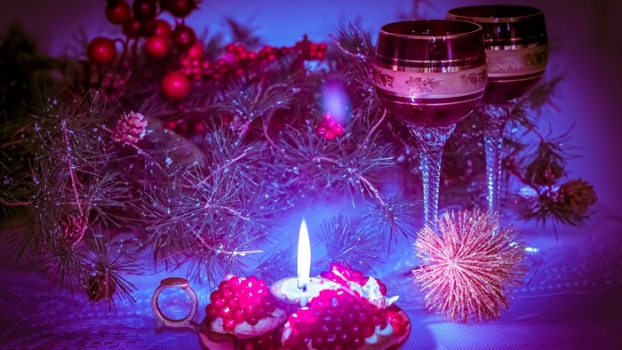 Christmas candle with wine glasses and pine branches