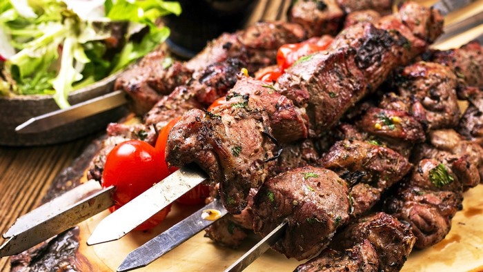 Barbecue meat skewers with tomatoes and salad