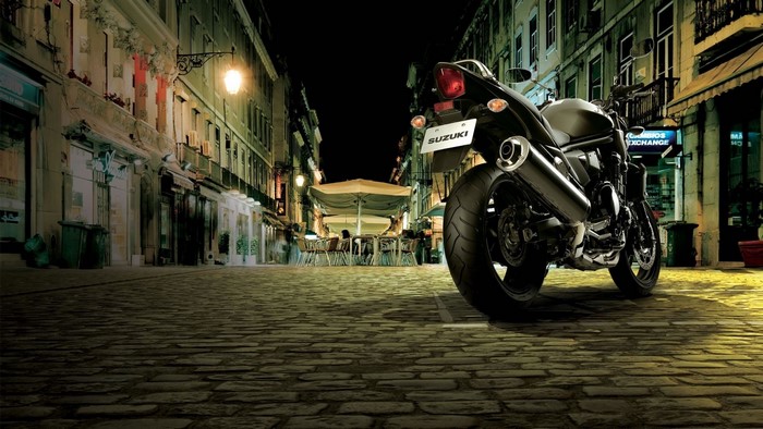 Suzuki Bandit motorcycle parked on cobblestone street at night