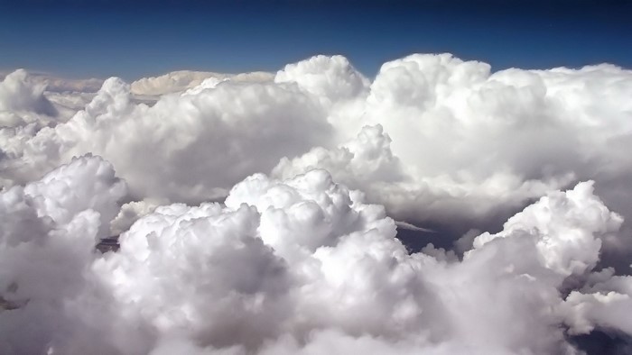 Fluffy white clouds against a deep blue sky