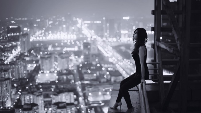 Woman on a Ledge Overlooking Cityscape