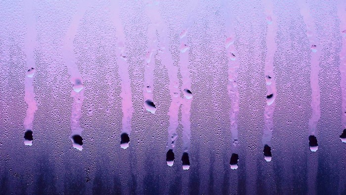 Condensation on glass with purple and pink hues