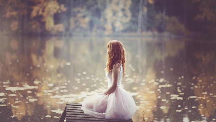 Girl in a tutu sitting on a dock