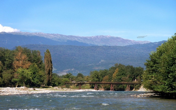 River and bridge with mountains in the background