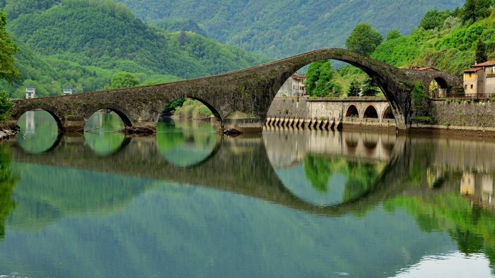 Stone Arch Bridge Over River with Mountain Reflections