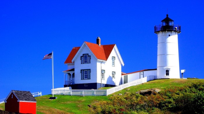 White Lighthouse and House with American Flag