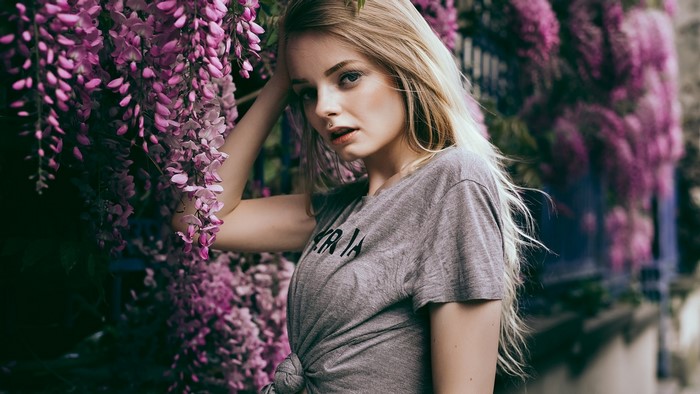 Young woman with blonde hair near purple flowers
