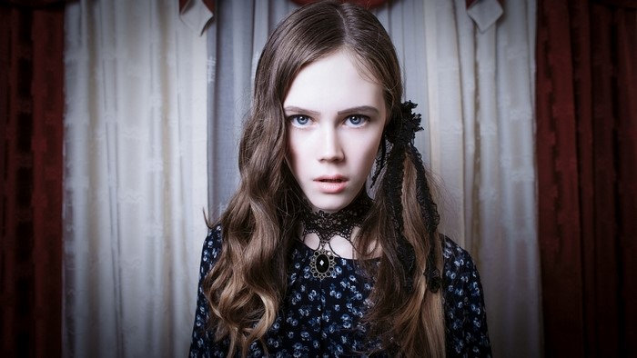 Young girl with blue eyes and dark dress