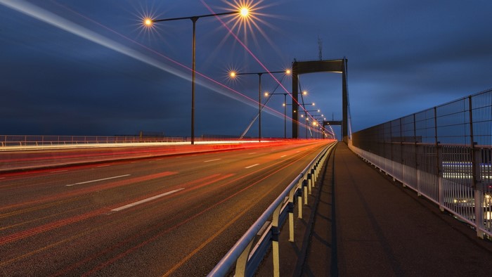 Long exposure of a bridge at night with light trails