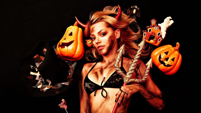 Woman in devil costume with Halloween decorations