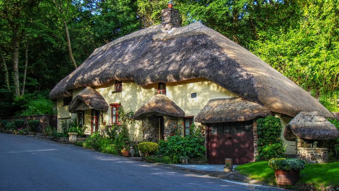 Thatched cottage with stone chimney and red windows