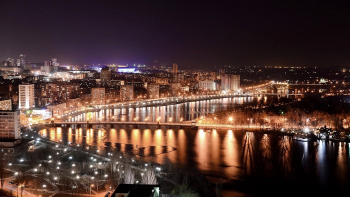 Night view of Donetsk city with river and illuminated buildings