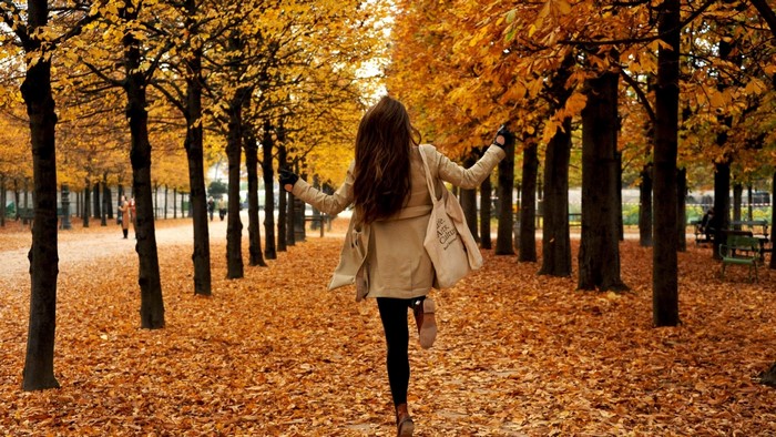 Woman running through an autumn park