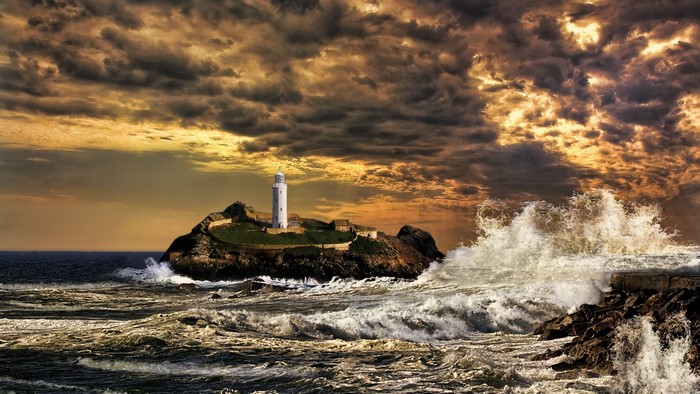 Lighthouse on rocky island with stormy sea
