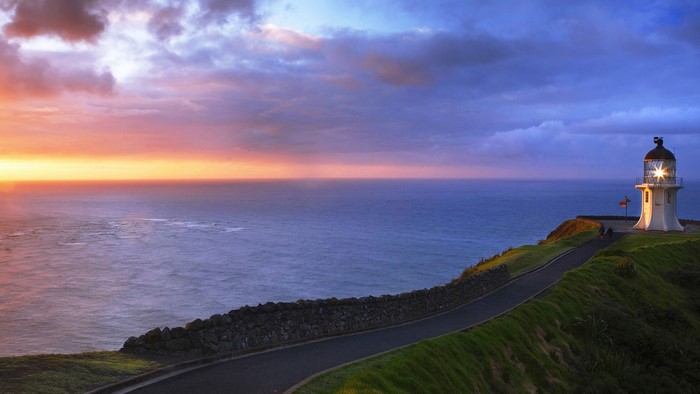 Road to lighthouse at sunset over the ocean