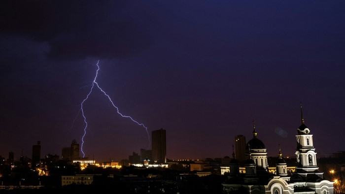 Lightning strikes over Donetsk city skyline at night