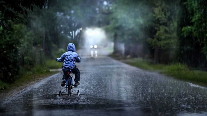 Child riding a bicycle in the rain