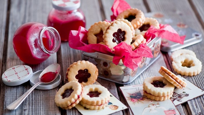 Jam-filled Linzer cookies with jars of jam