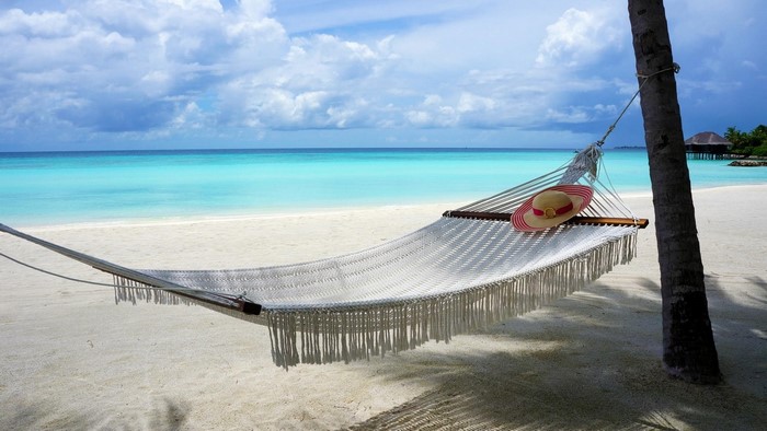 Hammock with a hat on a tropical beach