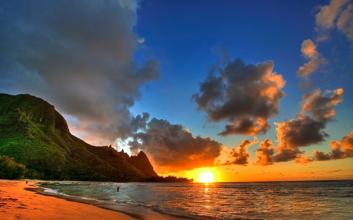 Sunset over a tropical beach with mountains