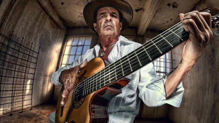Man playing guitar in abandoned room