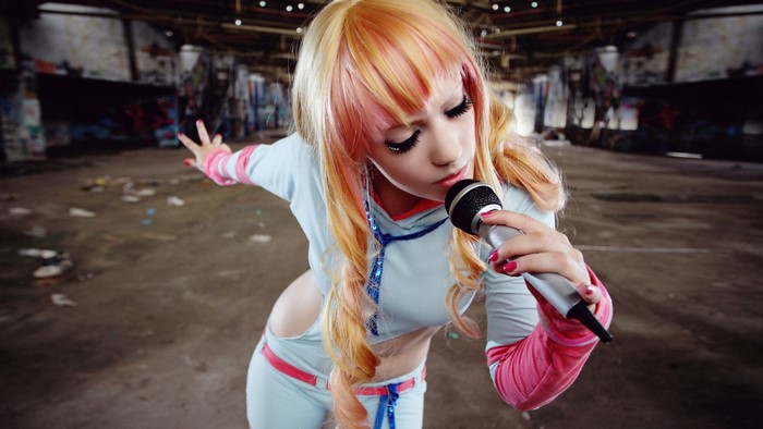 Girl with pink and blonde wig singing into microphone