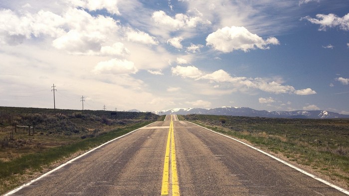 Open road with mountains and clouds
