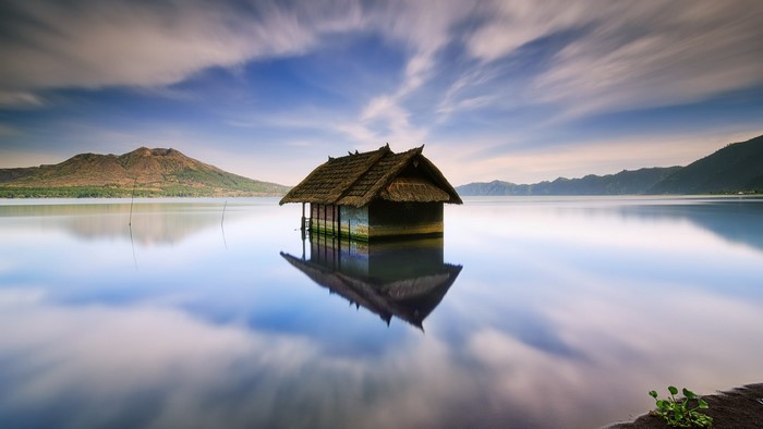 House on the water with mountain reflection