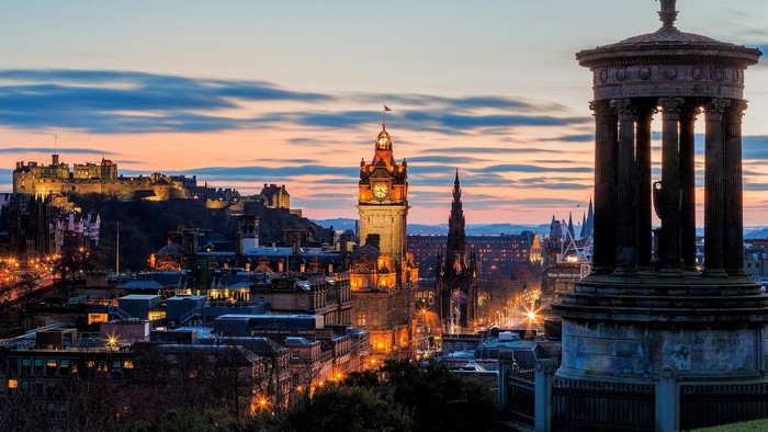 Edinburgh cityscape at dusk with castle and monument