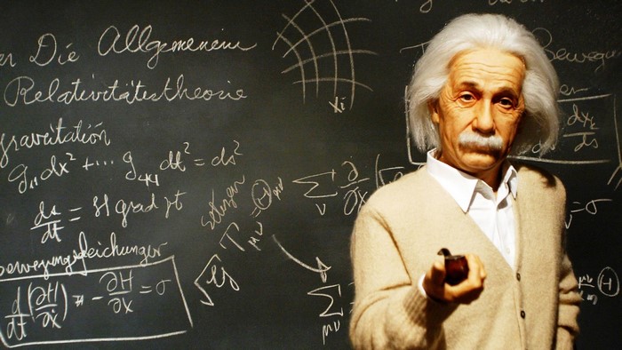 Albert Einstein with equations on a blackboard