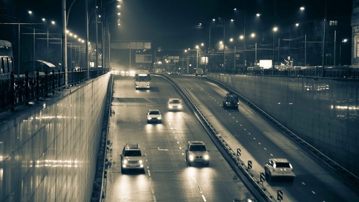Nighttime highway with cars and streetlights