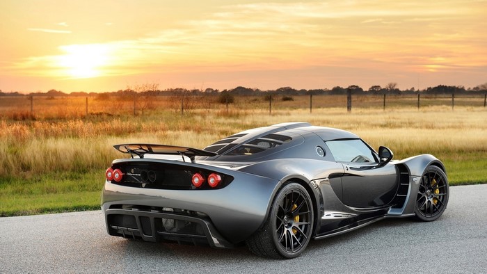 Silver Hennessey Venom GT sports car at sunset