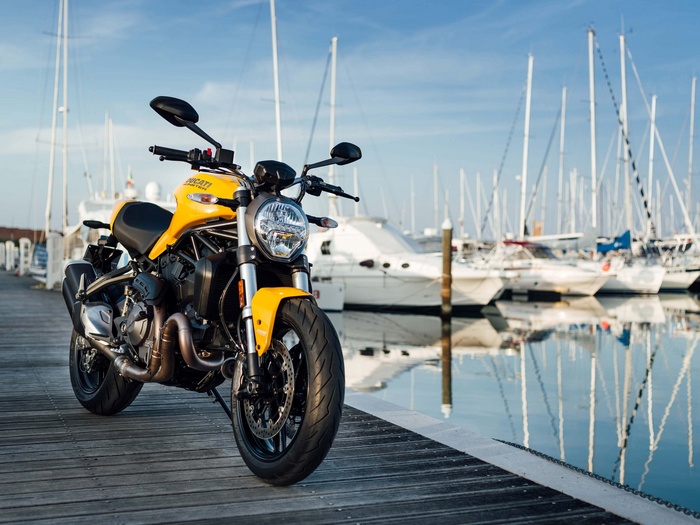 Yellow Ducati Monster 821 motorcycle in a marina