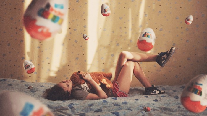 Girl with teddy bear and Kinder Surprise eggs