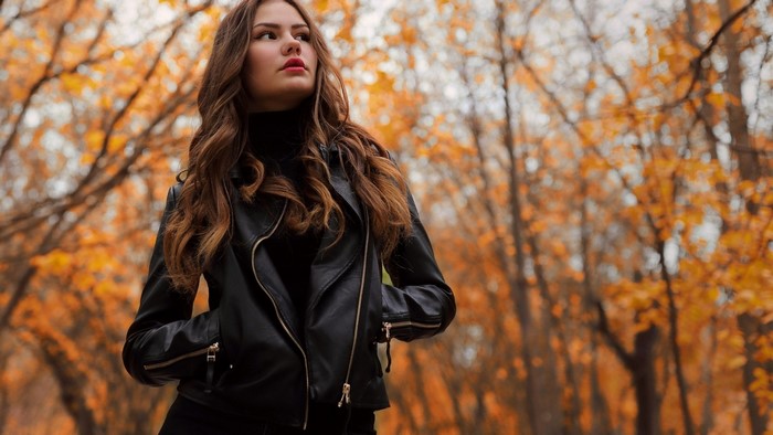 Woman in leather jacket in autumn park