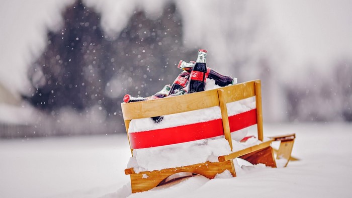 Coca-Cola bottles in a sled in the snow
