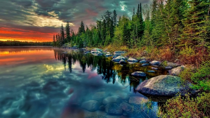Sunset over a lake with trees and rocks