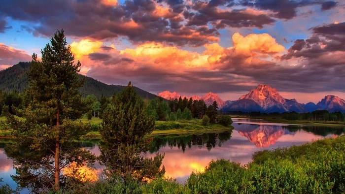 Sunset over mountains and lake with trees