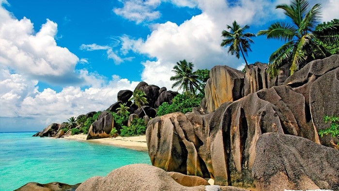 Tropical island with granite boulders and palm trees