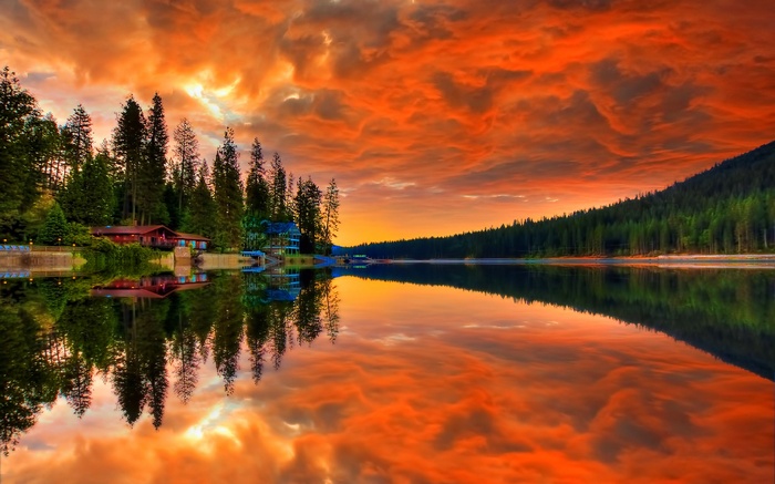 Sunset over a lake with pine trees and houses