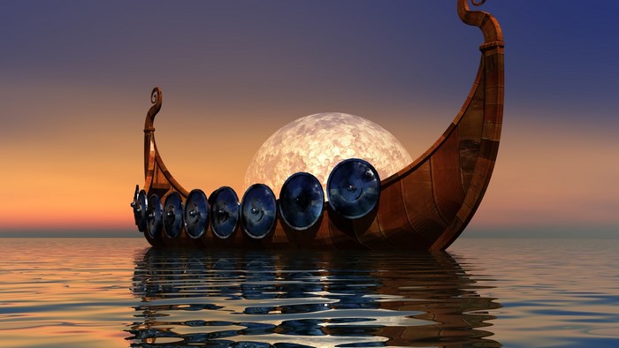 Viking longship sailing on the sea at sunset