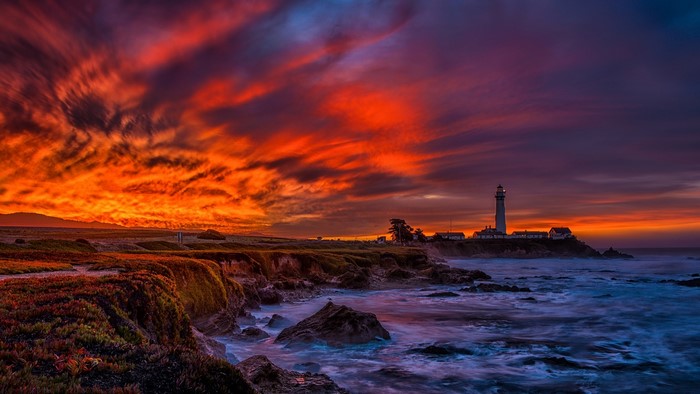 Lighthouse on a rocky coast at sunset