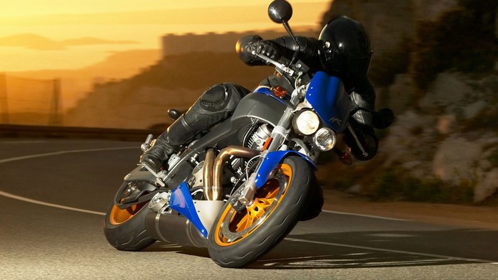 Motorcyclist riding a Buell motorcycle on a road at sunset
