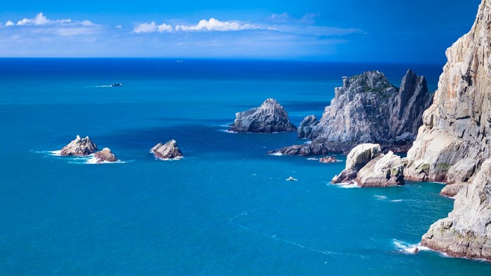 Blue sea with rocky islands and a boat