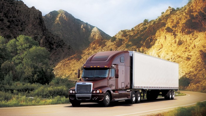 Freightliner semi-truck driving on a mountain road