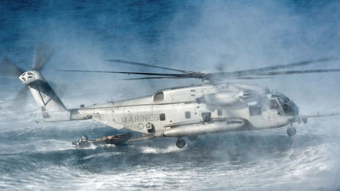 US Marines CH-53E Super Stallion helicopter over rough seas