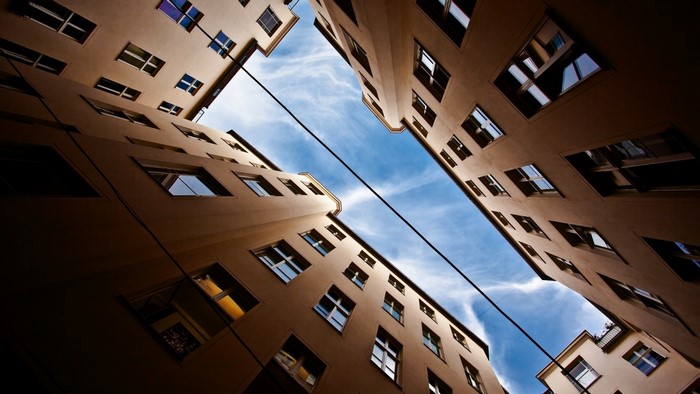 Looking up at apartment buildings against blue sky