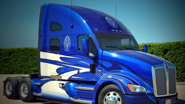 Blue Kenworth T700 semi-truck with custom flame graphics