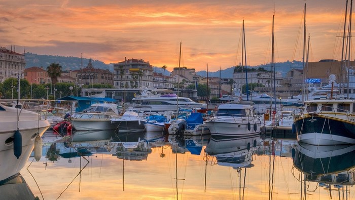 Boats docked in a harbor at sunset